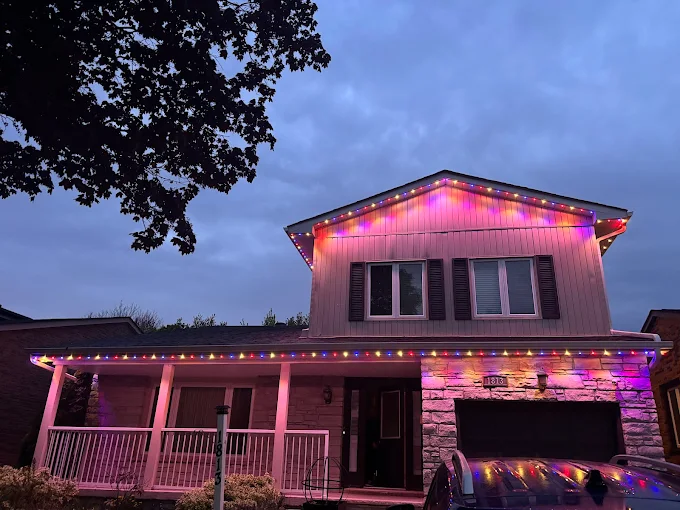 GTA home with pink and purple permanent LED roofline lighting at dusk