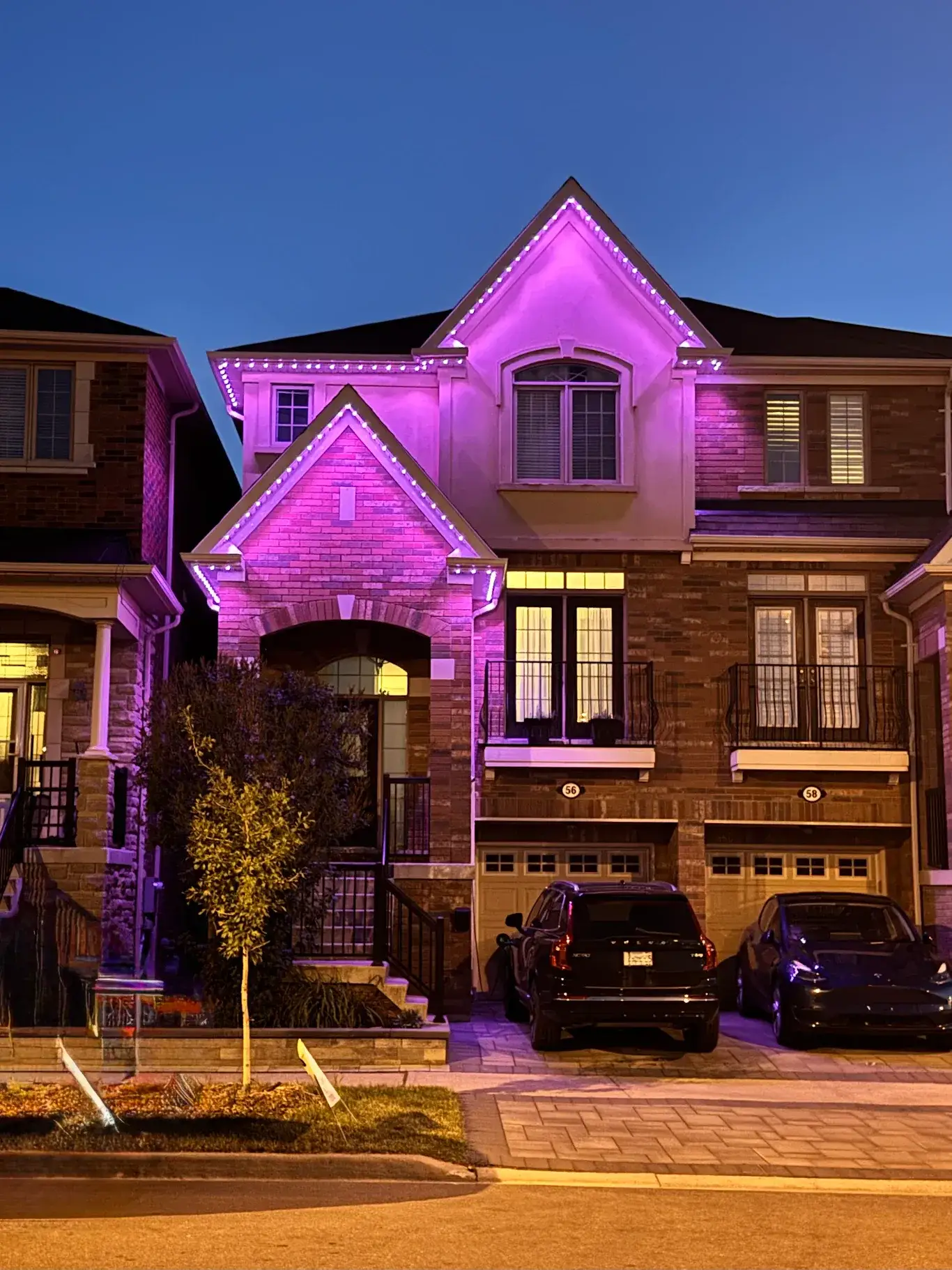 Purple and pink permanent outdoor LED lights dramatically illuminating a two-storey GTA townhome facade at night, showing the wow factor of Toronto Glow installations