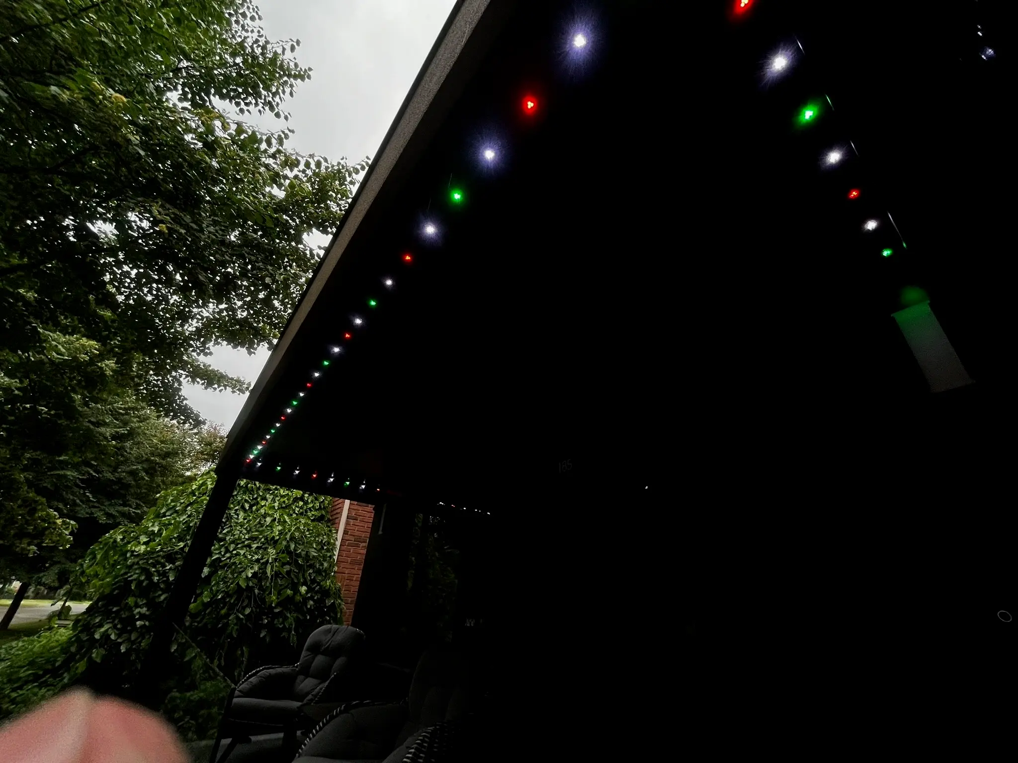 Close-up of permanent Christmas LED lights installed under a soffit by Toronto Glow — red, green, and white LEDs in a colour-matched track.