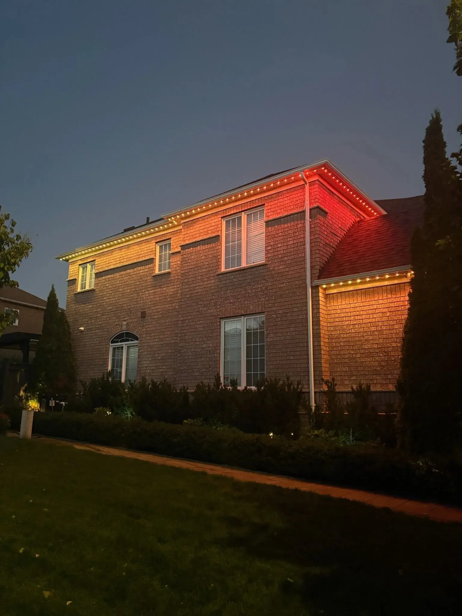 GTA brick home with permanent outdoor LED lighting in orange at night installed by Toronto Glow
