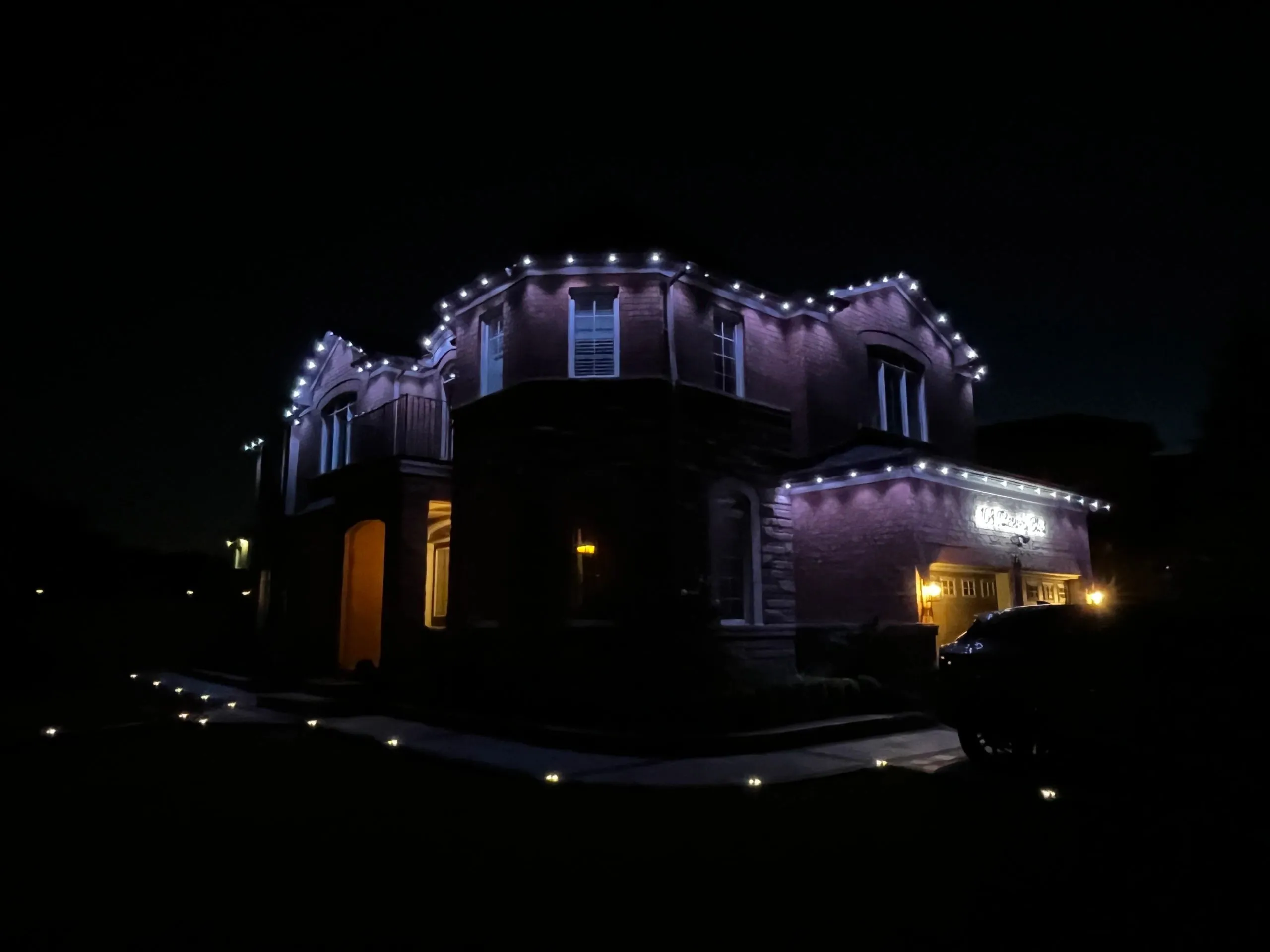 GTA luxury home with permanent outdoor LED lighting in warm white at dusk