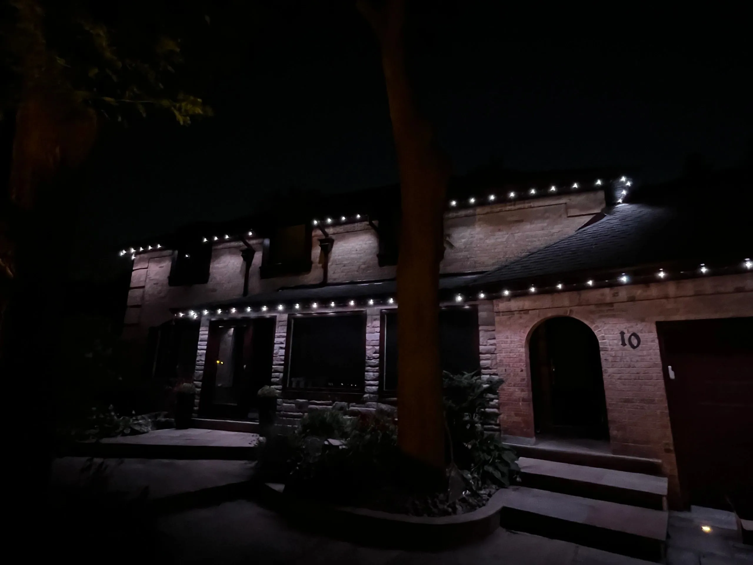 Toronto home with permanent outdoor LED lighting in warm amber at night