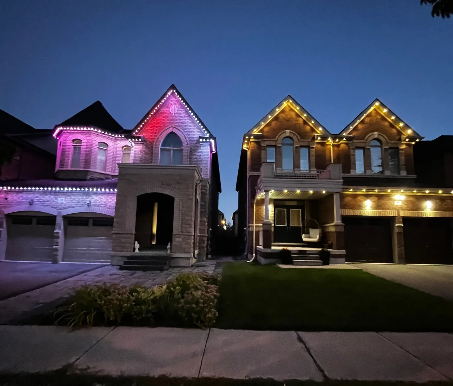 Two neighbouring GTA homes lit up for Diwali with permanent LED lights — one glowing in magenta and pink, the other in warm gold — at dusk