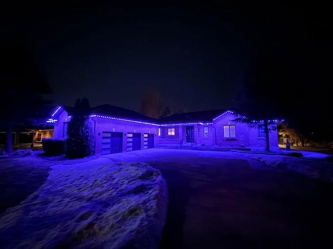 GTA bungalow with permanent outdoor LED lighting in blue in winter snow