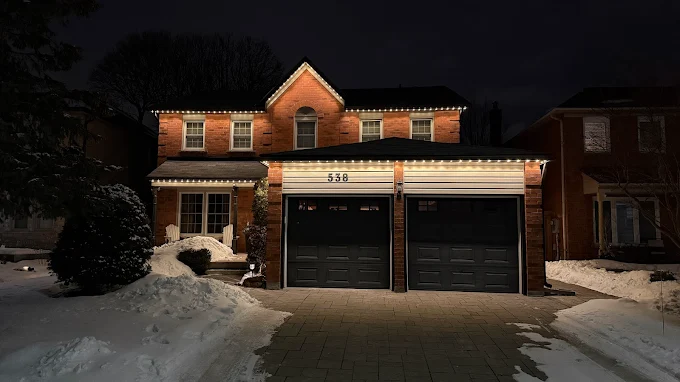 GTA brick home with permanent holiday lights in warm white in winter snow