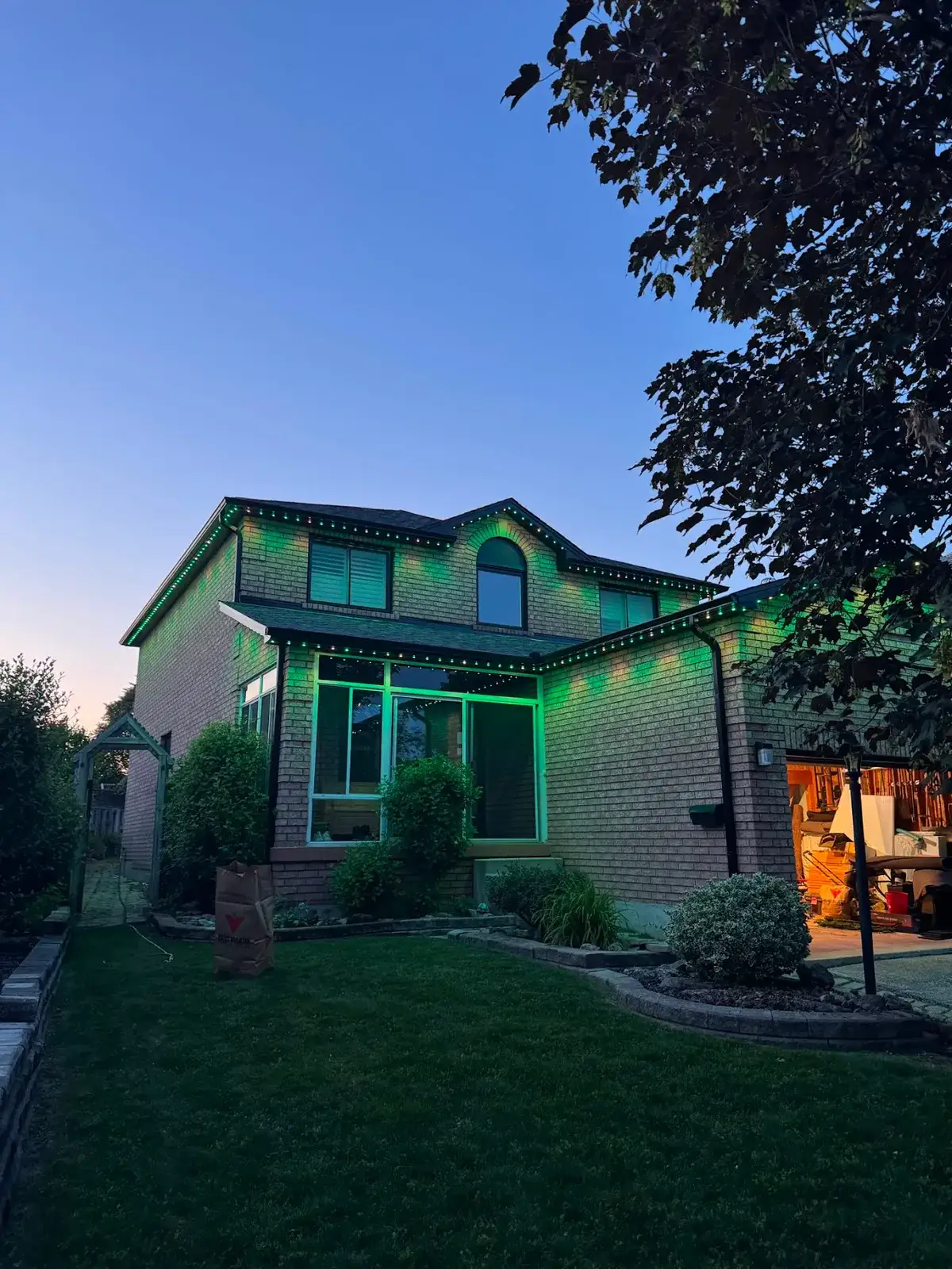 GTA home backyard with permanent outdoor LED lighting in green along the roofline at dusk installed by Toronto Glow