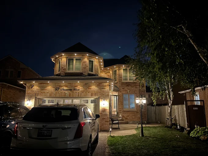 GTA brick home with warm white permanent LED roofline lighting at night