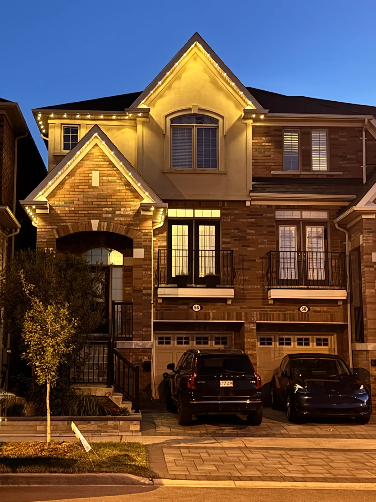 GTA townhome with permanent outdoor LED lighting in warm white along the gable peaks and roofline installed by Toronto Glow