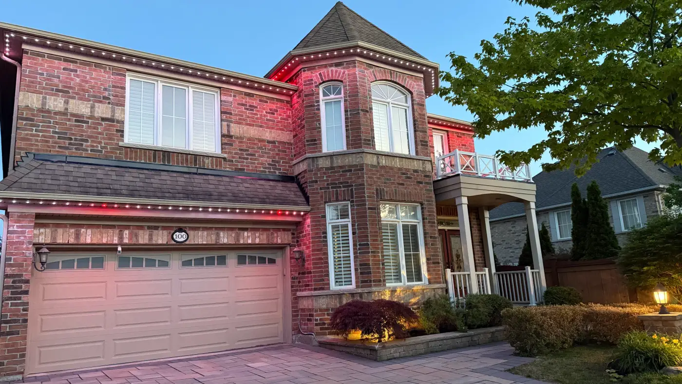GTA brick home with red permanent LED roofline lighting by Toronto Glow