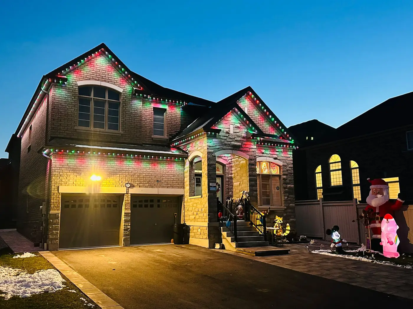 GTA home with red and green permanent Christmas lights installed by Toronto Glow along the roofline and soffits at dusk.