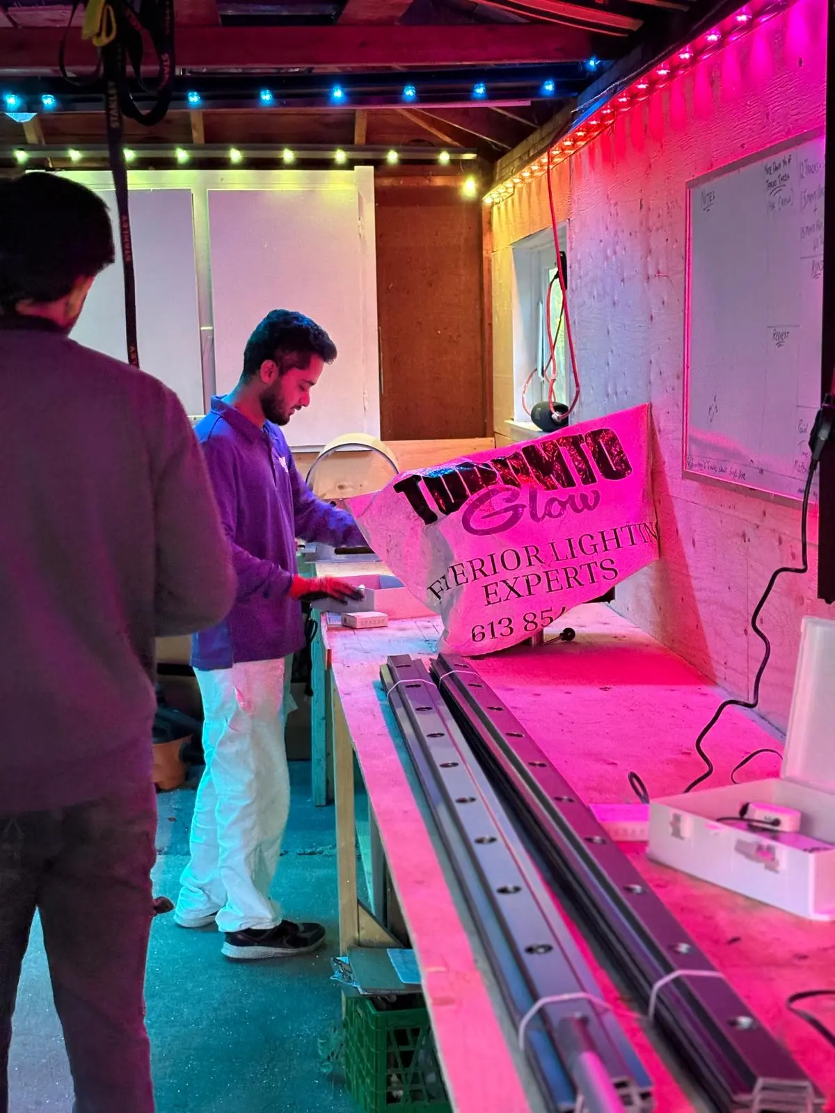 Toronto Glow team assembling LED tracks under pink and multicolour lighting