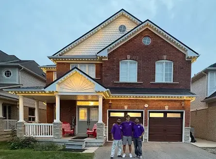 Toronto Glow installation crew standing in front of a completed permanent lighting install on a GTA home