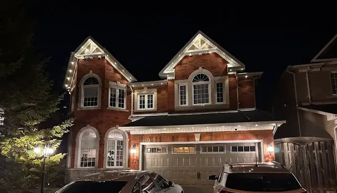 GTA brick home with warm white permanent LED roofline lighting at night