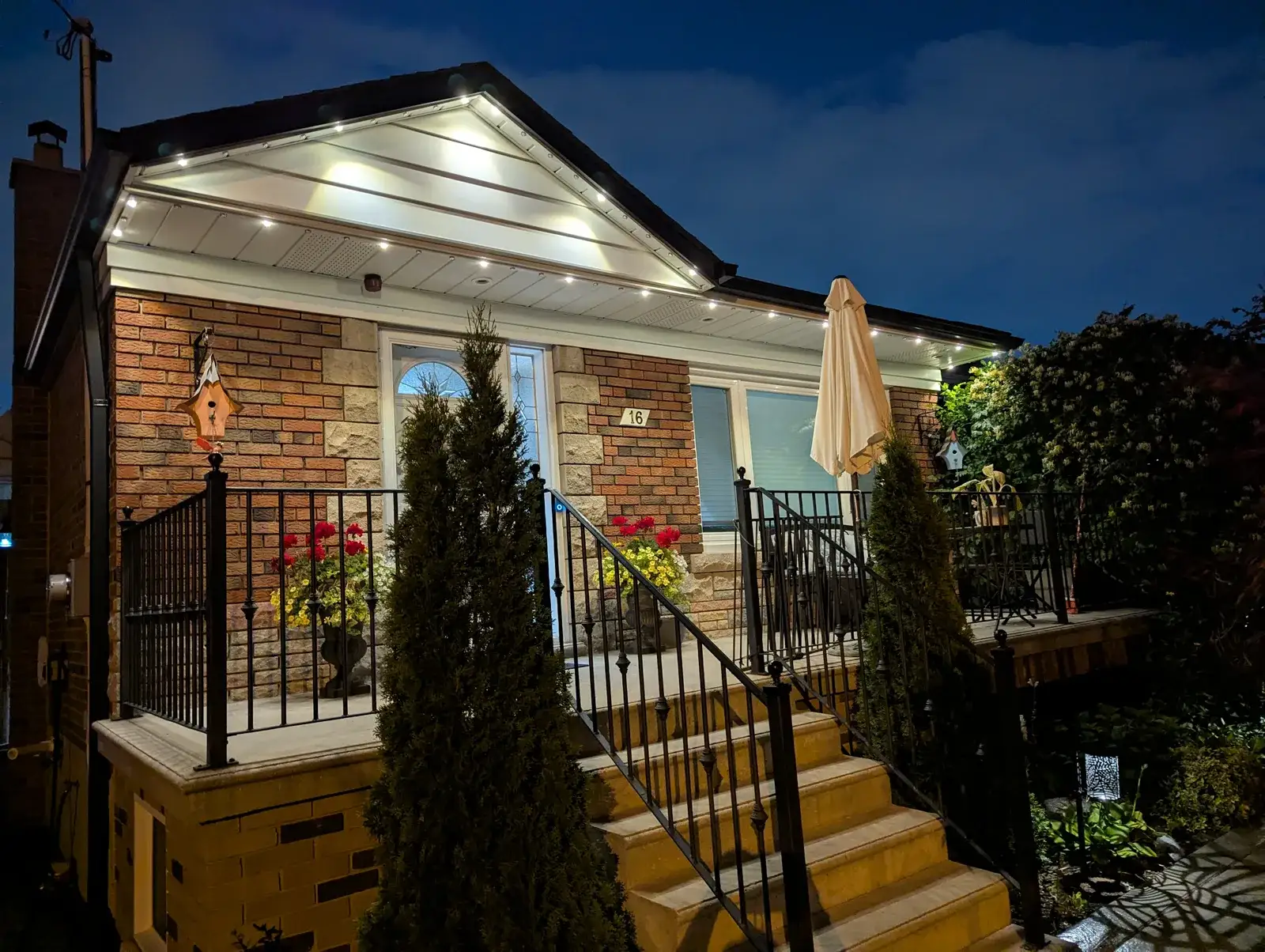 Luxury GTA home with warm white permanent LED roofline lighting and Toronto Glow sign on lawn
